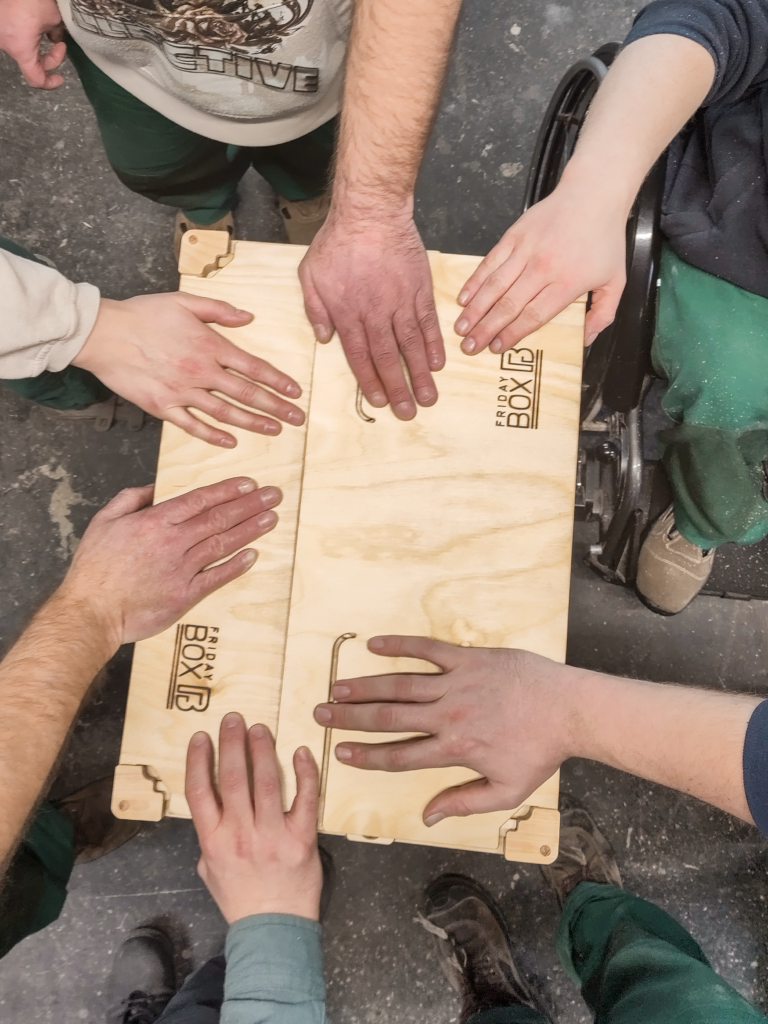 Hände des Teams auf einer FridayBOX