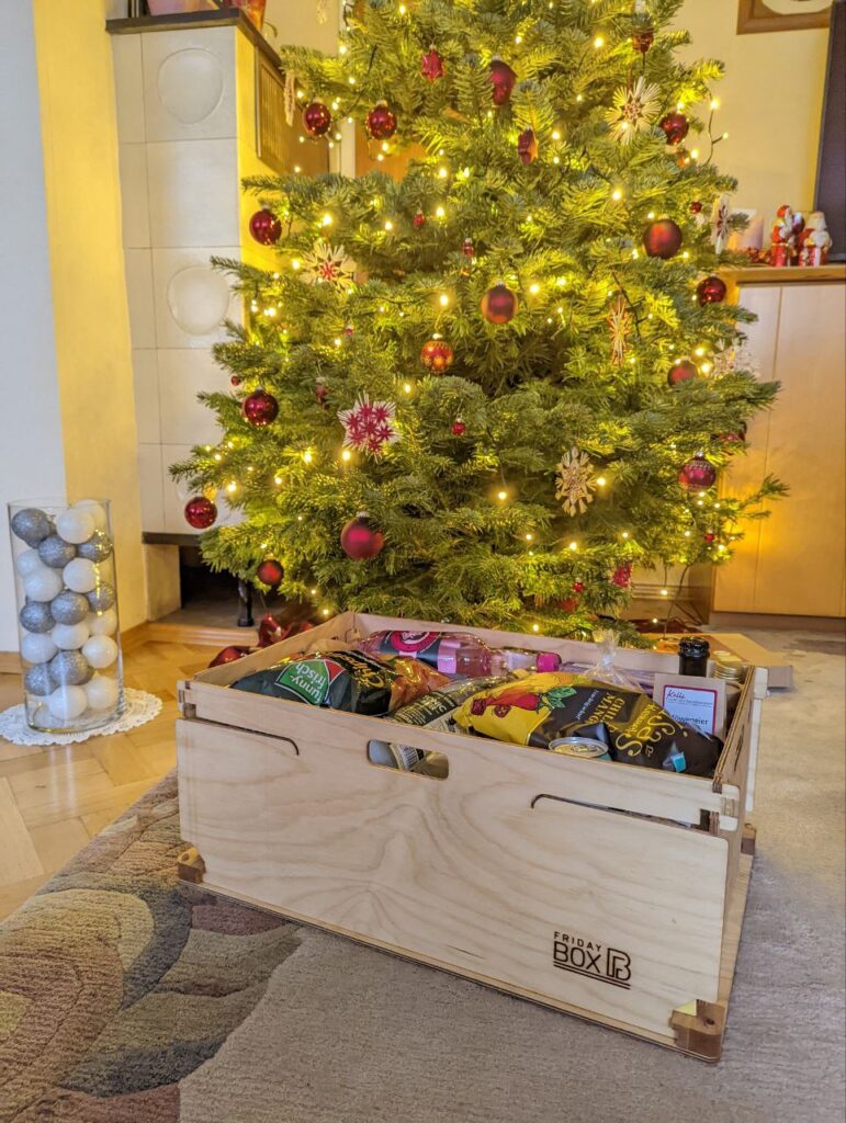 FridayBOX vor einem festlich strahlendem Weihnachtsbaum