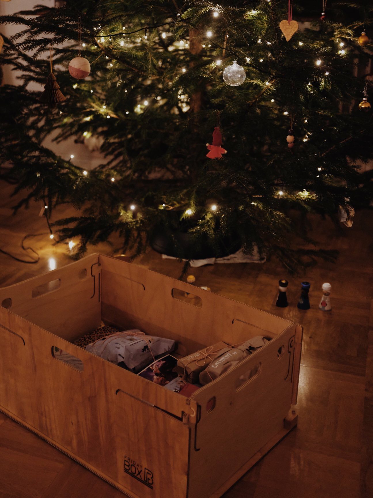 FridayBOX mit Geschenken gefüllt vor einem Weihnachtsbaum